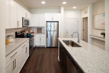 A kitchen with white cabinets and a stainless steel appliances